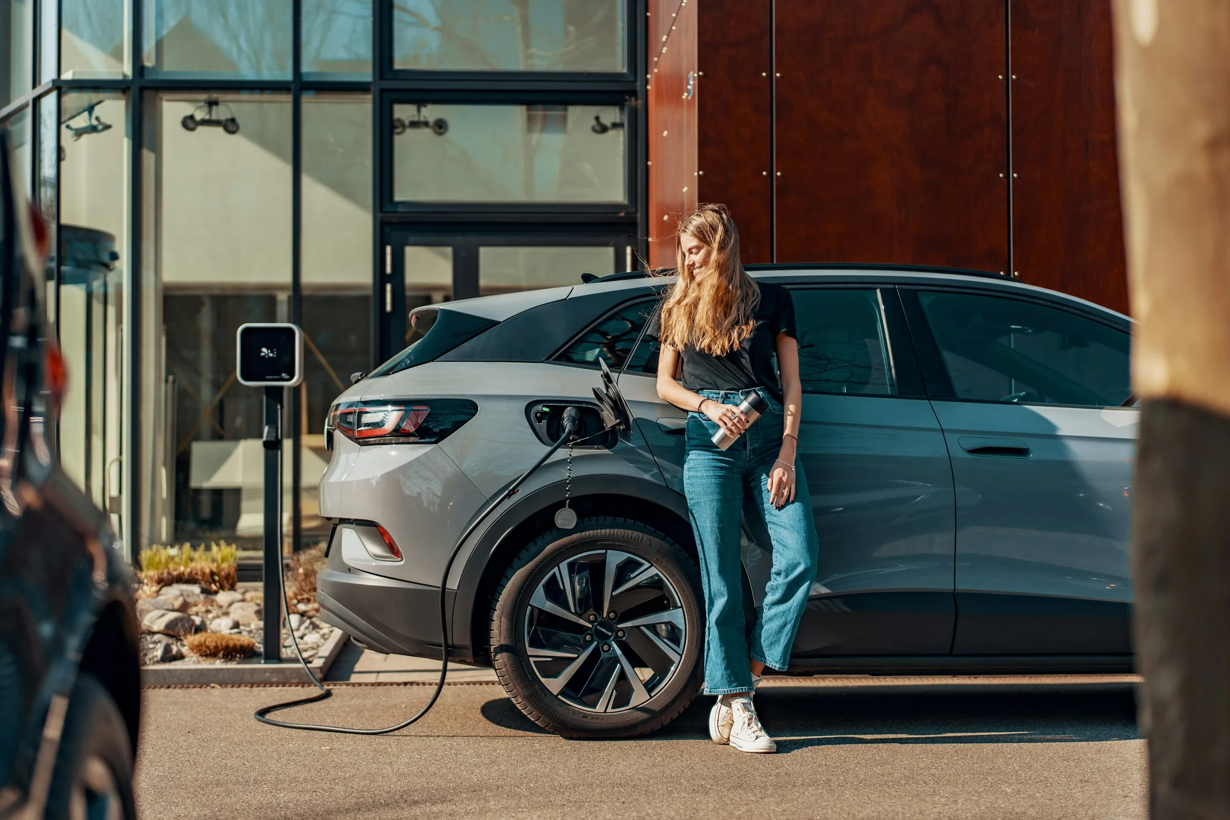 Voiture électrique en charge sur une borne, devant un bâtiment d’entreprise